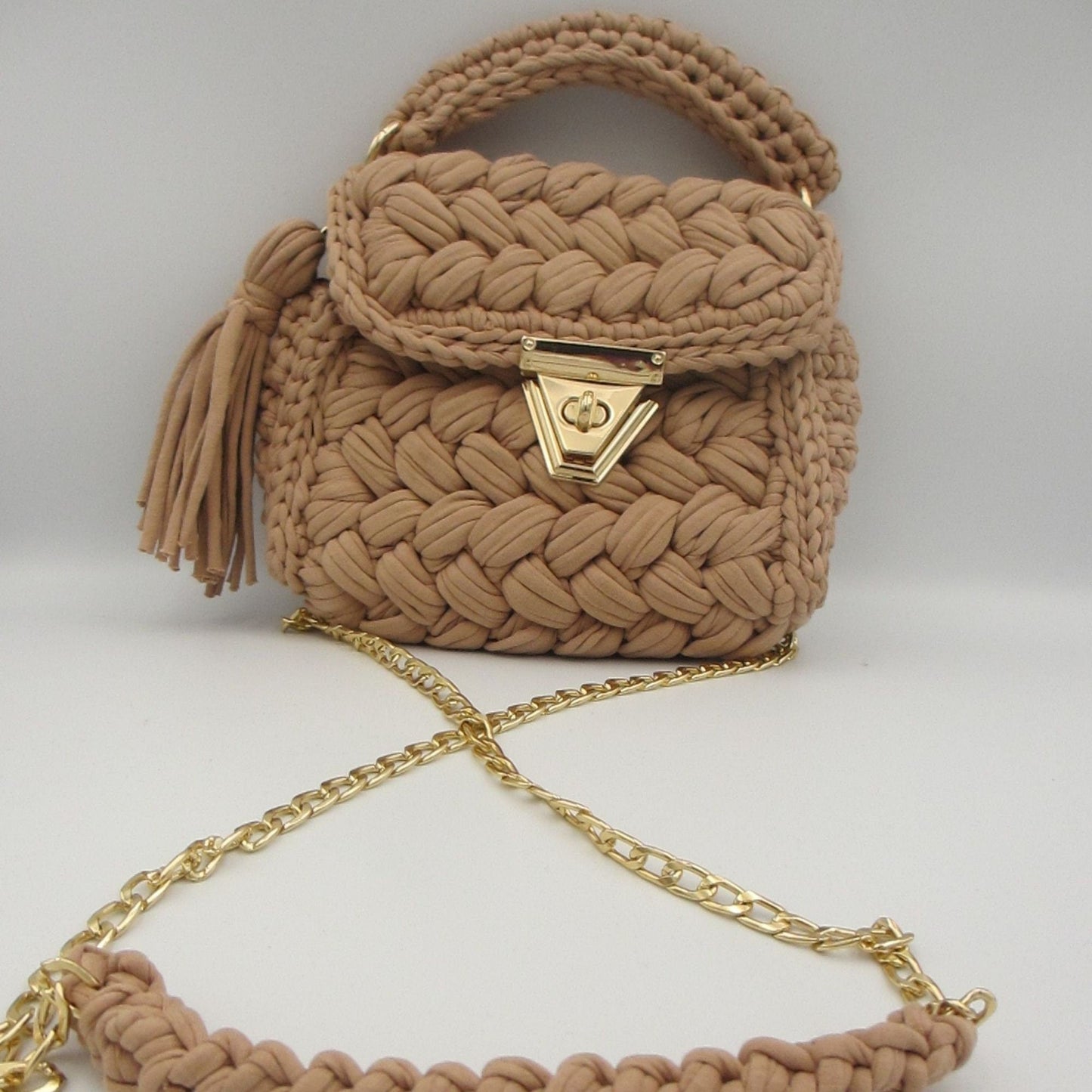 A vintage style black leather tote bag with gold metallic accents and zipper closure.
